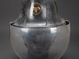 an old fireman ' s helmet on a stand on a gray background