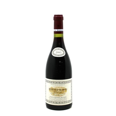 the bottle of wine is sitting on a white surface