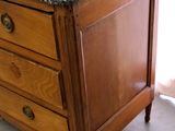 a wooden dresser with a marble top in a room