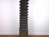 une photo représentant une grande sculpture en bois posée sur un parquet en bois dur
