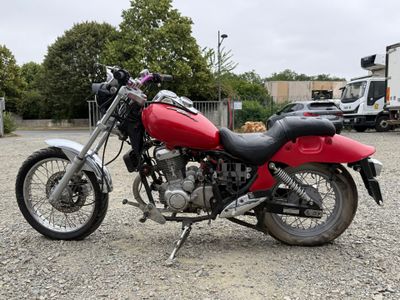 a red motorcycle that is parked in a parking lot