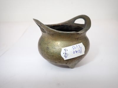 un petit pot en métal muni d'une étiquette