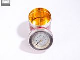 a silver and gold clock sitting on top of a white table