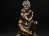 une image représentant une statue en bronze d'une femme assise sur un socle