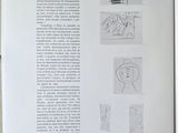an open book with drawings on it on a table