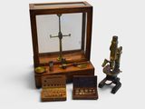 un microscope miniature et d'autres objets exposés dans une vitrine