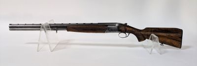 un fusil posé sur un socle transparent, devant un fond blanc