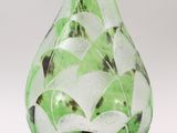 a glass vase with a green and white design on it