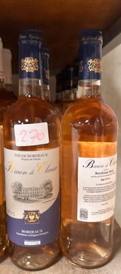 plusieurs bouteilles de vin sont alignées sur une étagère dans un magasin