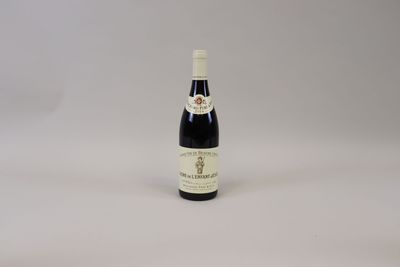 une bouteille de vin posée sur une table blanche