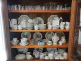 une armoire en bois remplie d'une multitude d'assiettes et de tasses