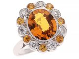 une image représentant une bague ornée d'une grosse citrine entourée de diamants orange et blancs