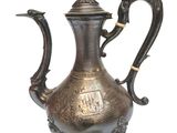 a silver tea pot with a bird on it