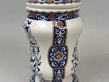 a blue and white vase with a lid on a table