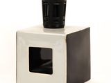 a black and white cup sitting on top of a white box