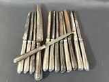 six couteaux d'argenterie et un couteau sur une table