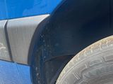 a close up of a blue truck with a flat tire