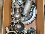 une boîte remplie d'objets en argent posée par terre