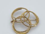 a close up of three gold rings on a white surface