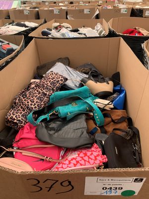 une boîte en carton remplie d'une multitude de sacs à main et de sacs à bandoulière