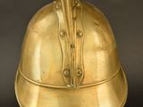 brass helmet on a black surface with a black background