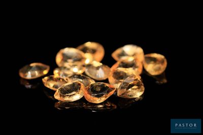 un gros plan sur un bouquet de diamants jaunes posés sur une surface noire