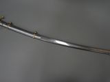 an old sword with a gold handle on a gray surface