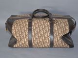 sac de voyage beige et marron, orné d'un motif monogramme et doté de poignées en cuir marron