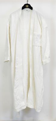 une photo d'une chemise blanche suspendue à un cintre accroché au mur