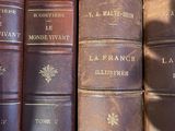 several old books are lined up in a row on a shelf