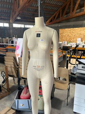 un mannequin posé sur un socle dans un entrepôt