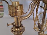 a gold candle holder on a table next to a mirror