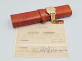a brown leather case with a gold watch on top of it