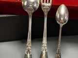 three spoons and a fork sitting on a table