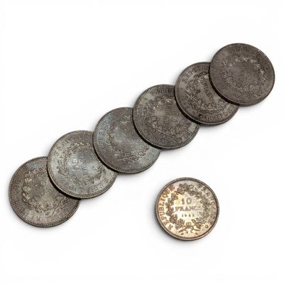 several coins are shown next to a penny on a white surface