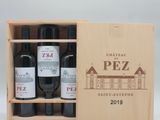 trois bouteilles de vin dans un coffret en bois sur une table
