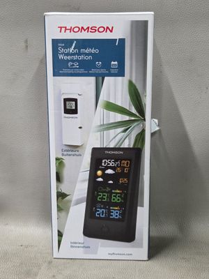 une boîte sur laquelle figure une horloge numérique, posée sur une table
