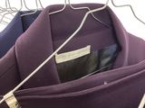three coats hanging on a clothes rack in a closet