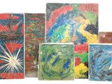 Plusieurs tableaux de différentes couleurs et formes sont exposés sur une surface blanche.