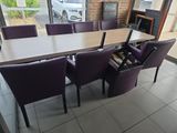 une table avec des chaises violettes et un casier à bouteilles au milieu de la pièce