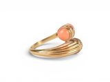 a close up of a gold ring with an orange stone