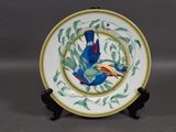 a plate with a bird on it sitting on a stand