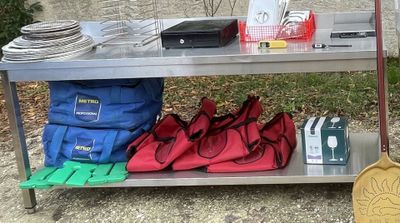 a metal table with a bunch of bags and bags on it