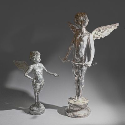 deux statues représentant un garçon et une fille debout l'un à côté de l'autre
