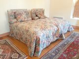 deux lits dans la chambre, avec un tapis au sol