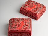 two small red boxes sitting on top of a white table