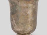 an antique silver cup on a pedestal on a gray background