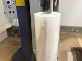 a picture of a roll of clear plastic next to a machine