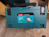 La perceuse Makita est posée par terre à côté d'une boîte à outils.