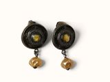 two pairs of earrings with yellow beads on them on a white surface